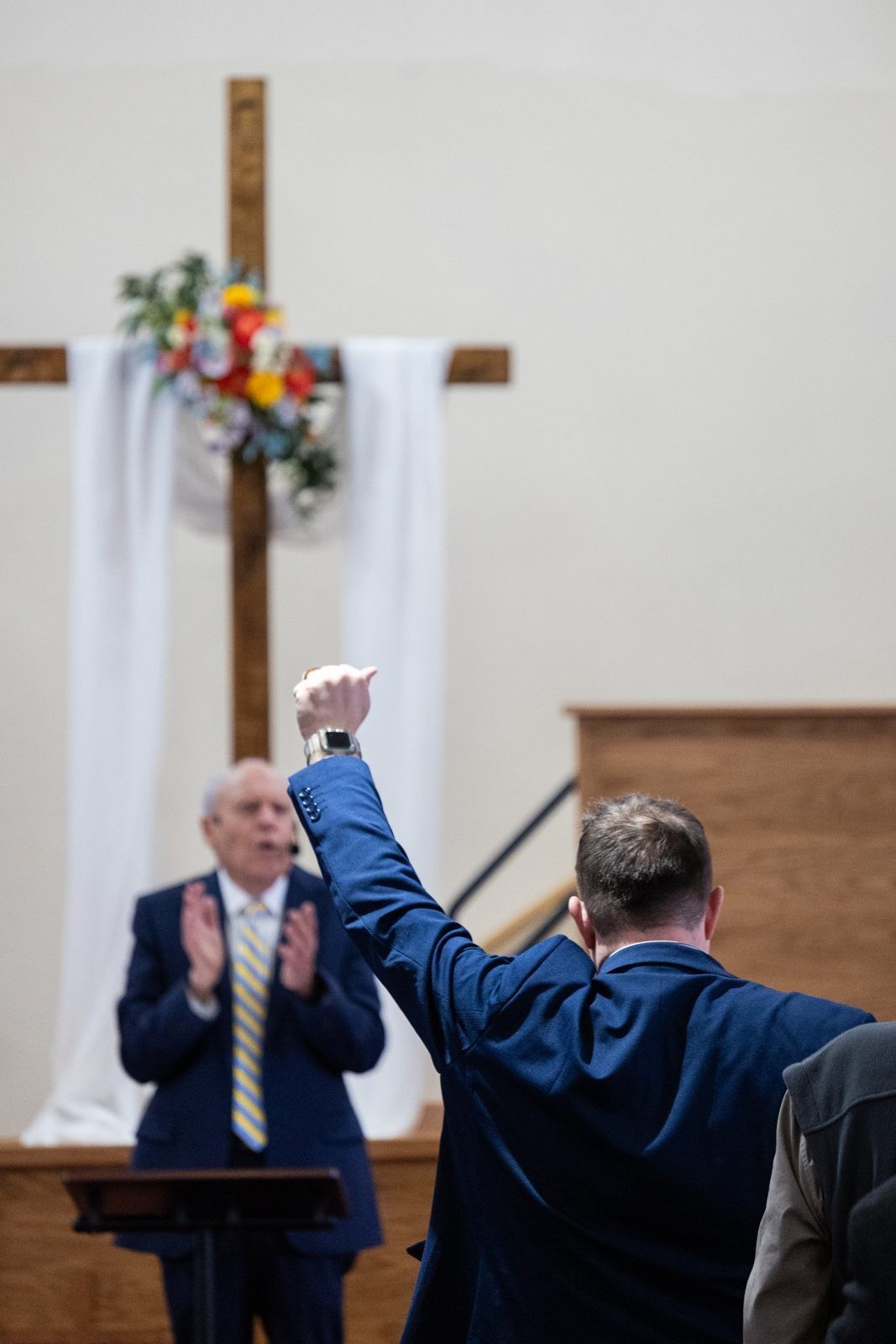 Church worship service with raised hand in the sanctuary.